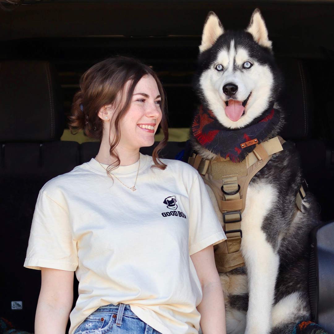 husky dog with girl wearing a light tan shirt with good boy logo on left chest