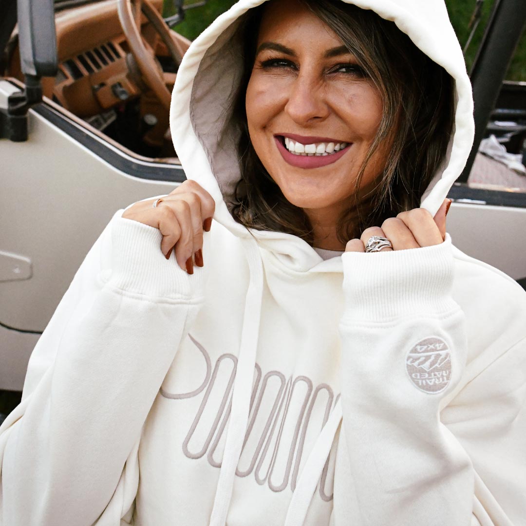 A woman wearing a white Jeep hoodie with grille logo