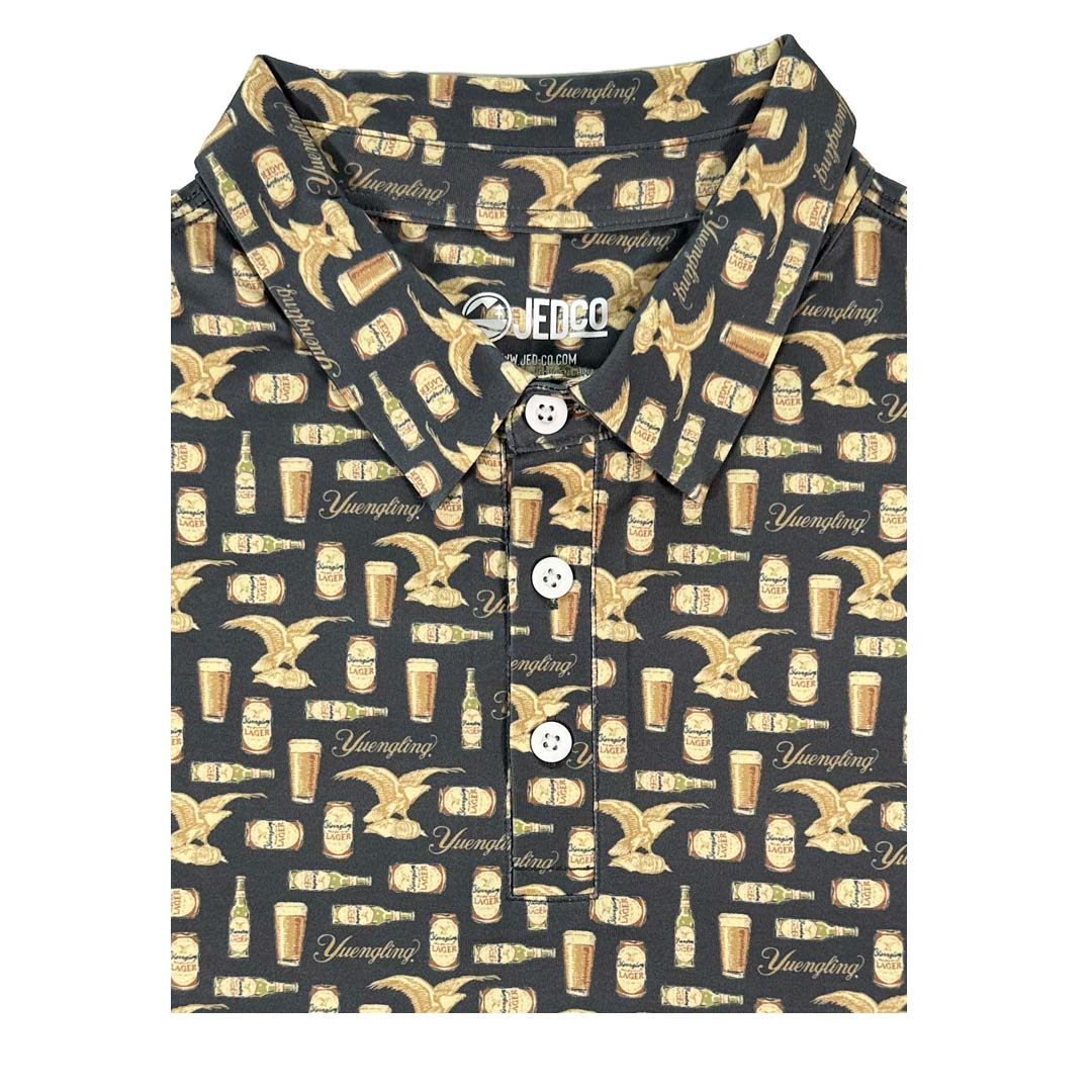 Yuengling dark grey polo with a beer bottle, can, logo and eagle repeat pattern,