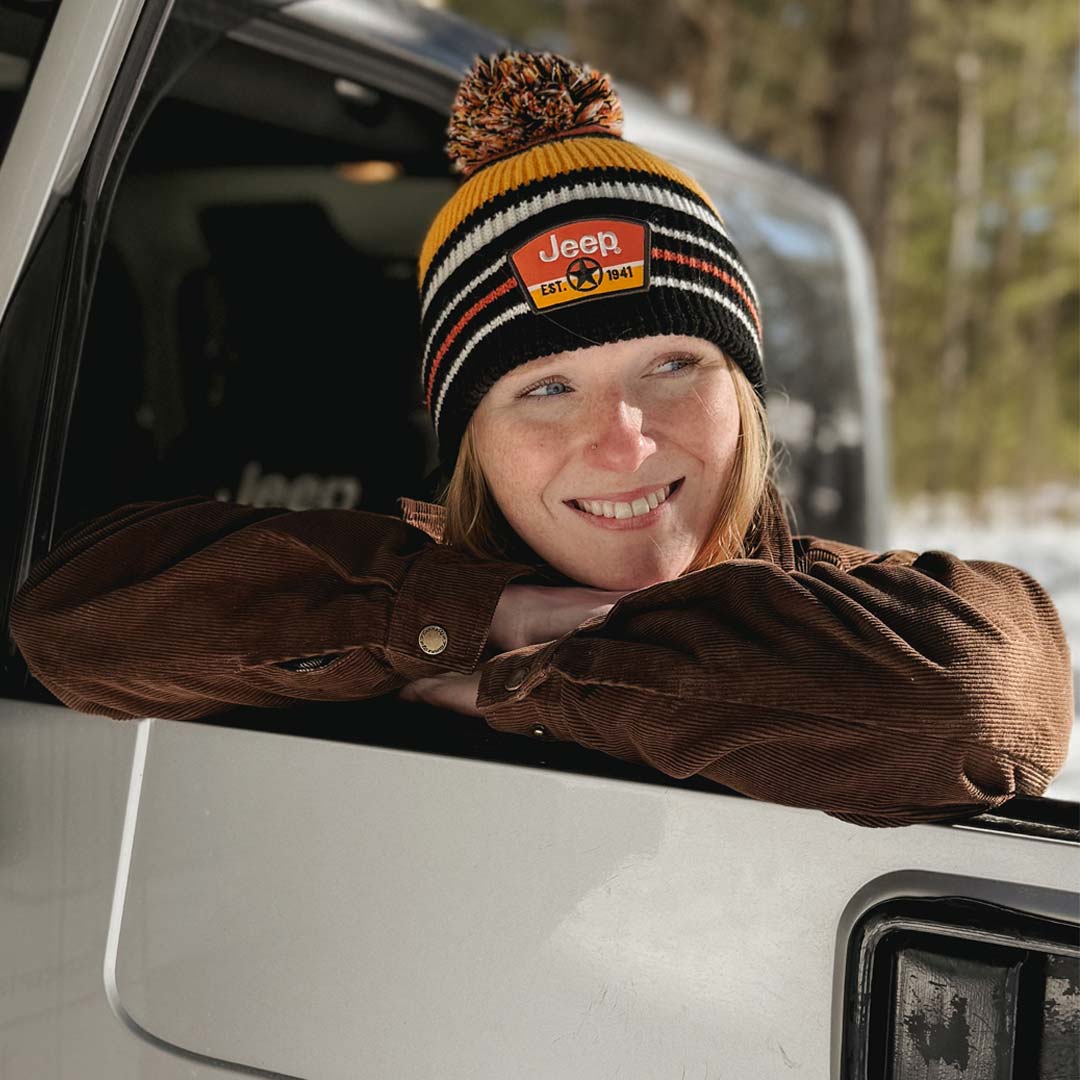 woman wearing a black and orange knit Jeep hat