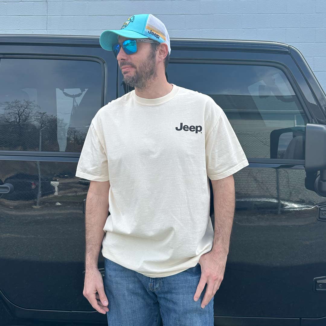 male wearing Jeep hat and T-shirt in front of a black Jeep
