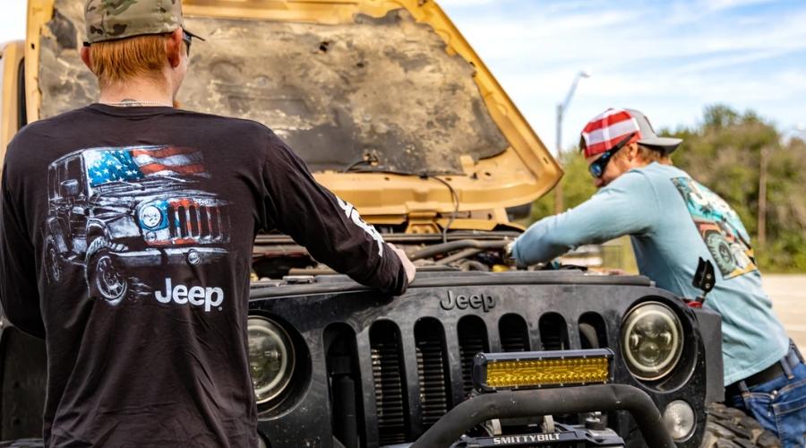 Two men changing the oil in their jeep