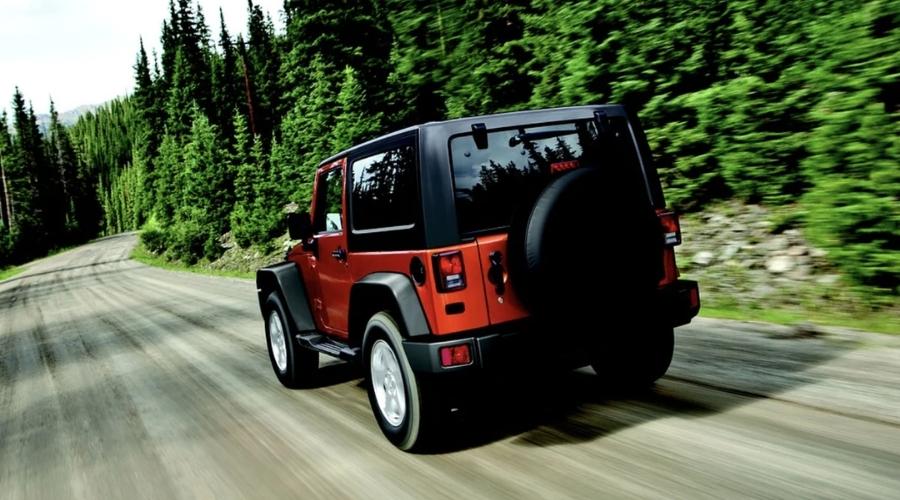 red jeep driving down the road