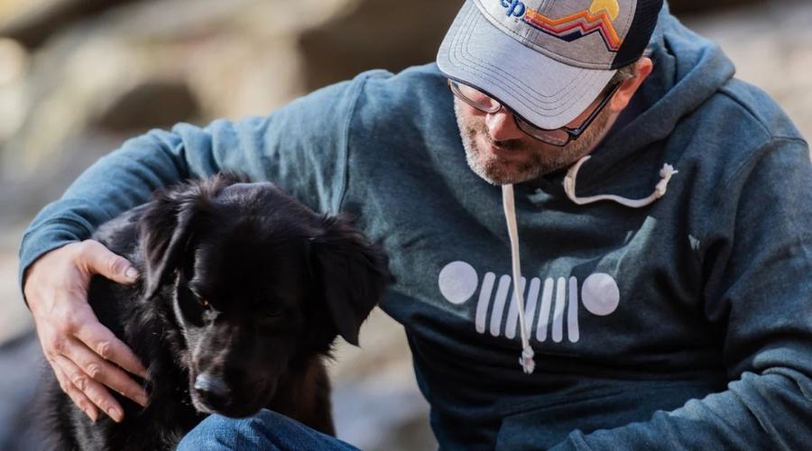 Man and his dog around a jeep