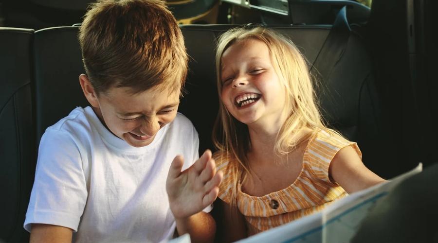 two children inside a jeep laughing