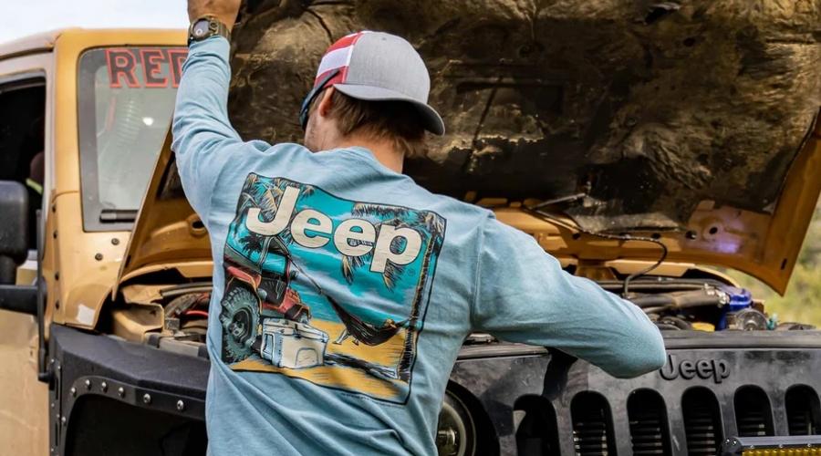 Man opening the hood of his jeep and doing maintenance