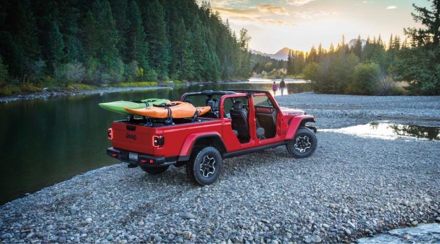 Red jeep with two kayaks on the back