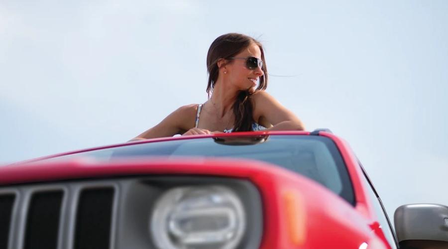 Girl standing above her red jeep