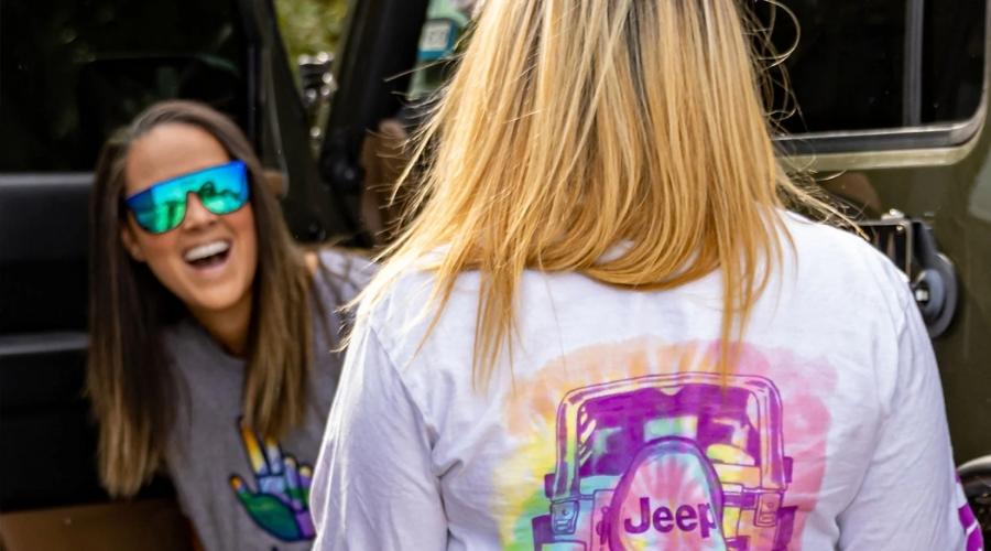 Two women wearing jeep clothing and smiling
