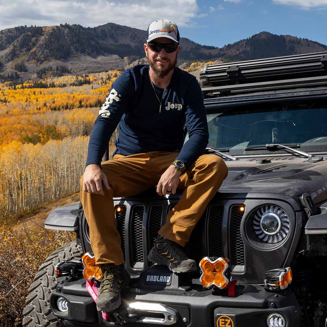 Front of vintage life off road long sleeve shirt with jeep logo on right sleeve and left chest on male sitting on jeep