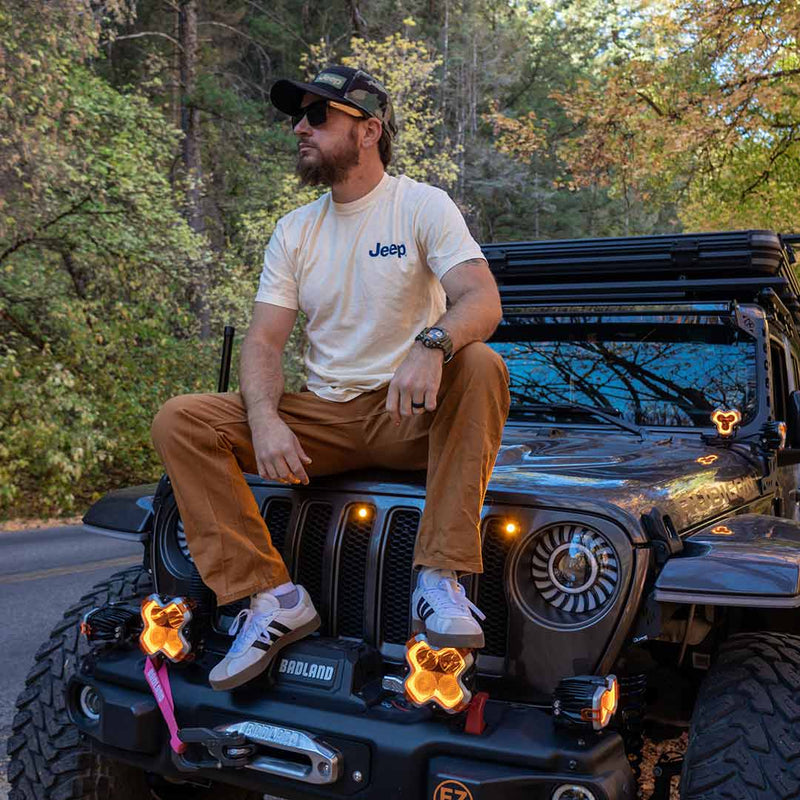 jedco jeep duck trail blazer t-shirt front with jeep patch on upper left on male sitting on jeep outside