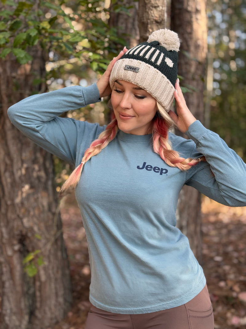 woman wearing jeep long sleeved shirt and beanie, both with the logo on it, outdoors