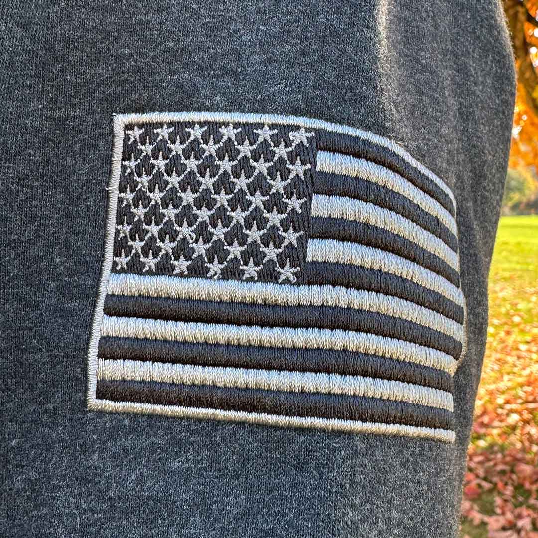 Black hoodie with embroidered Jeep logo and USA Shield close up shot of USA flag on sleeve.