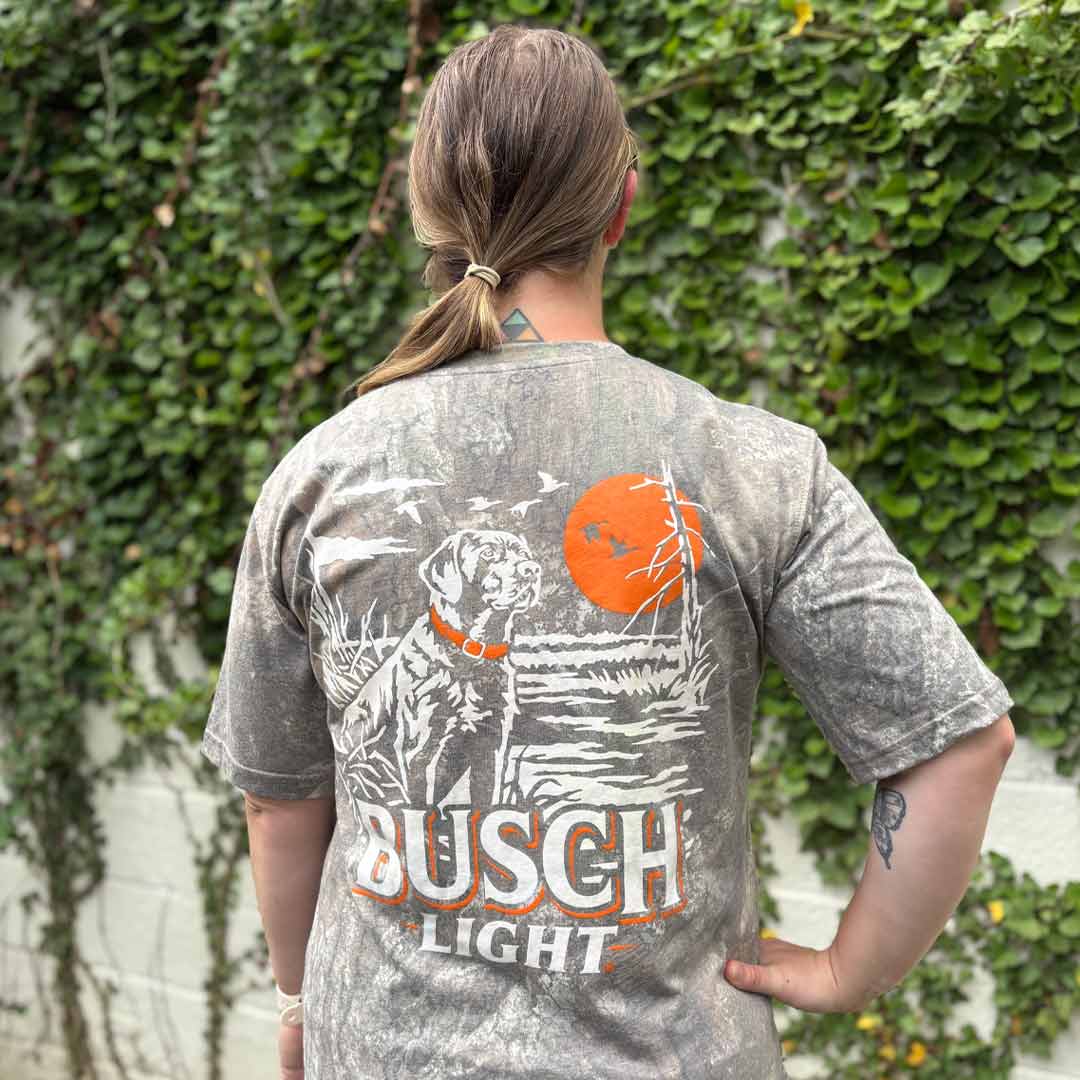 woman in outdoor scene wearing a camo Busch Light t-shirt