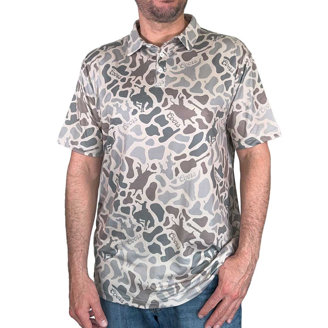 Male model wearing Coors Cowboy Camo Polo with custom western icons featuring a cowboy hat, bull rider and guitar. 