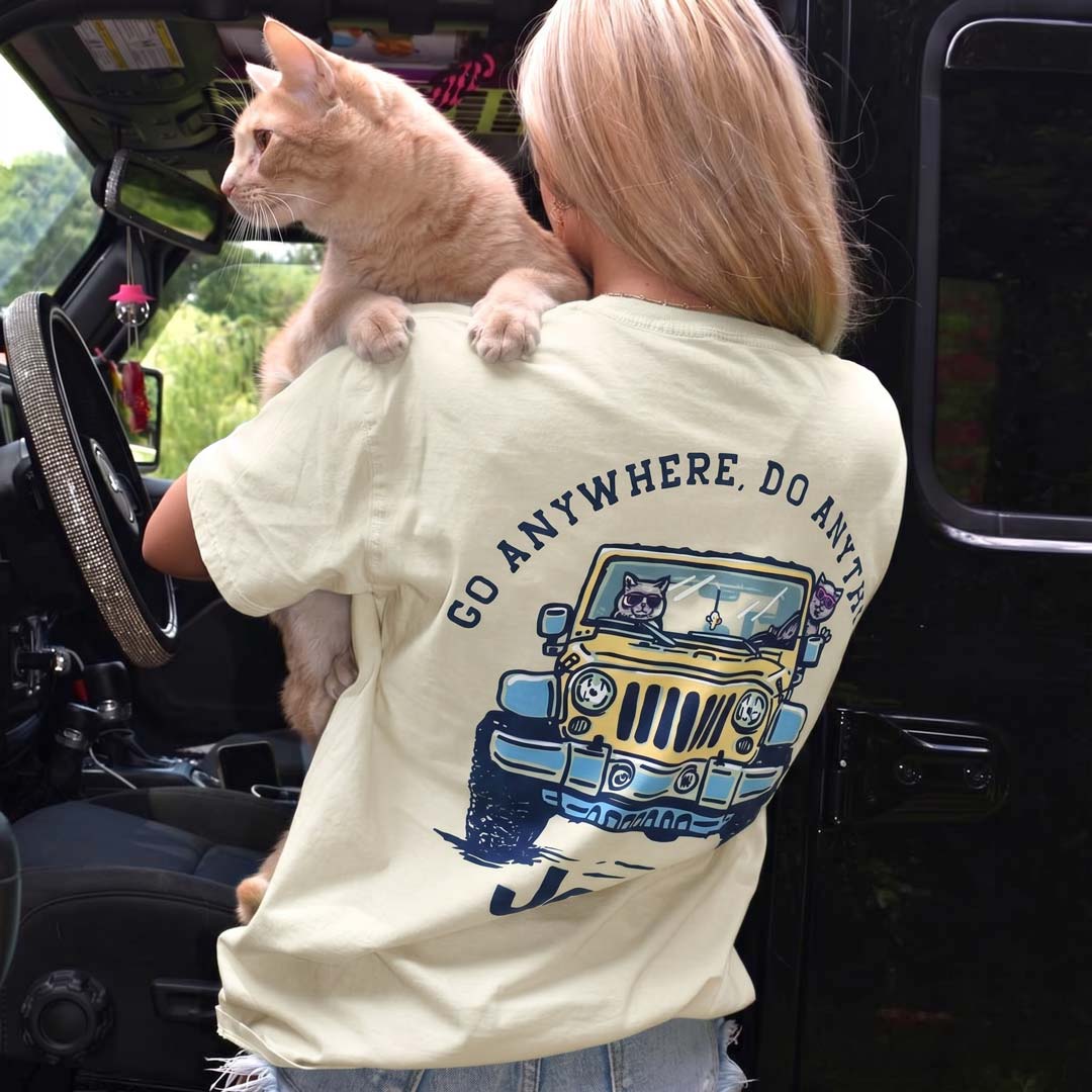 Person holding a cat with a t-shirt featuring a jeep cat graphic.