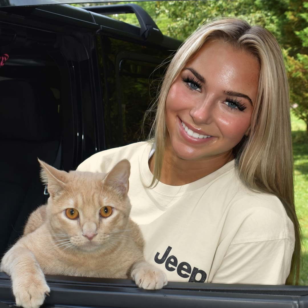 Woman with a cat in the back of a Jeep vehicle
