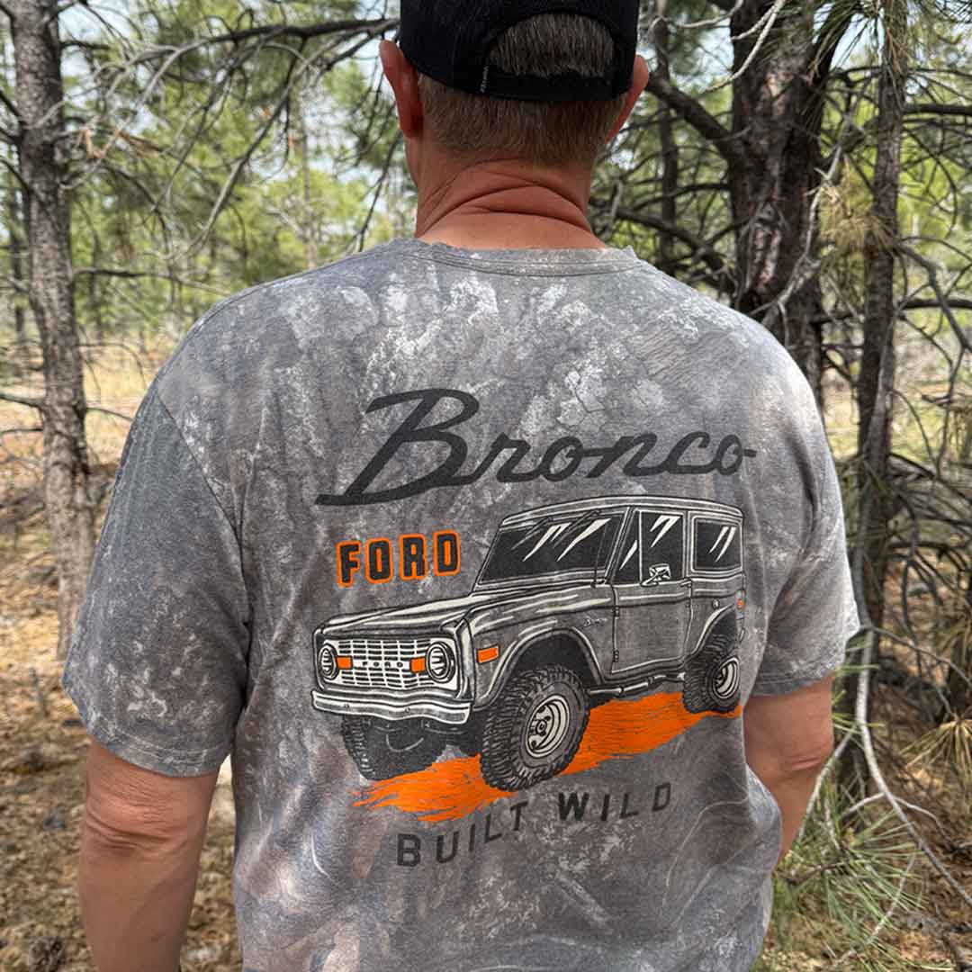 Man in wooded environment wearing a camo Ford Bronco shirt