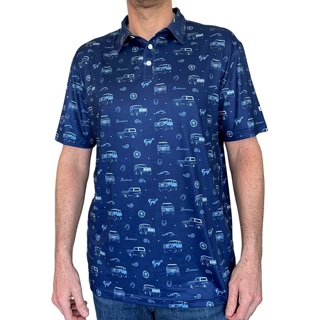 Man wearing blue Bronco Vintage Polo shirt with vehicle designs on a white background