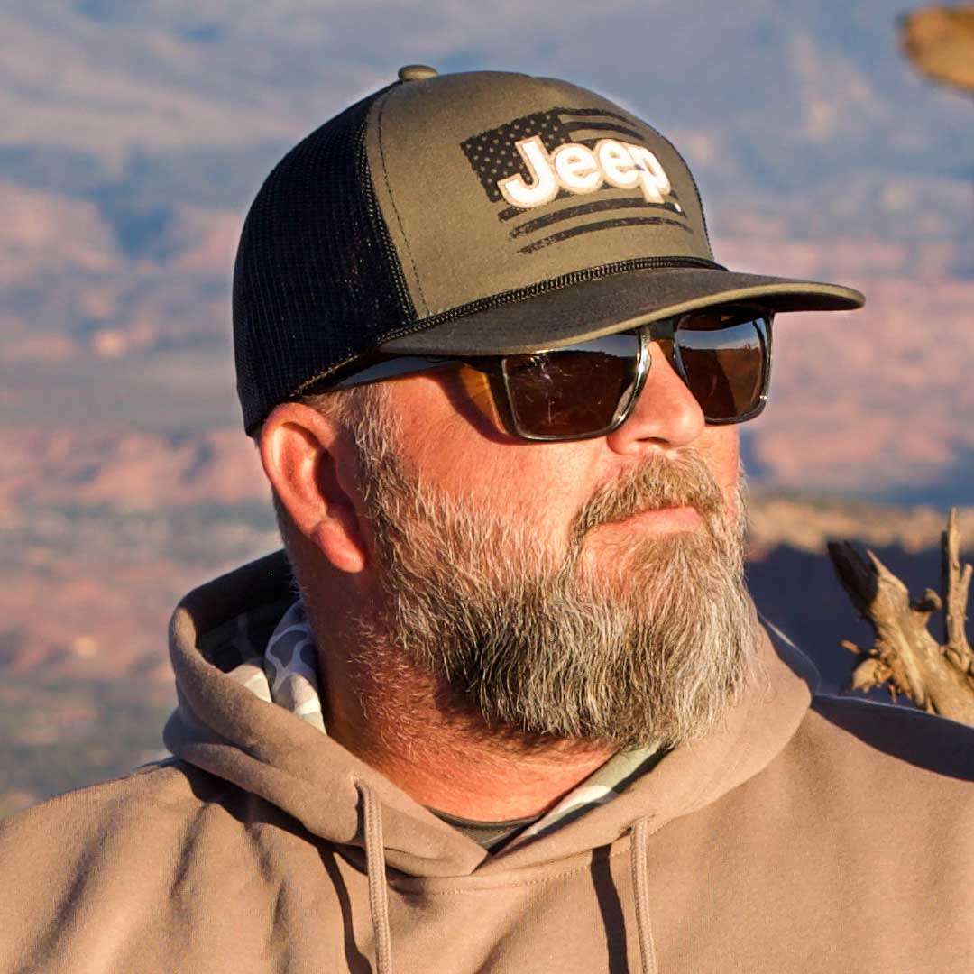 man wearing green hat with Jeep logo and American flag