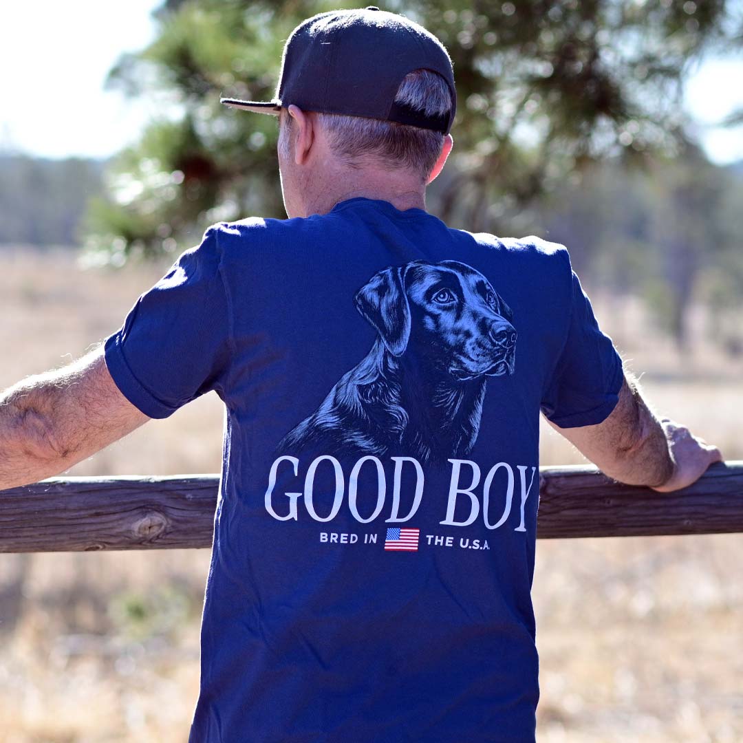 man wearing blue t-shirt with dog and American flag