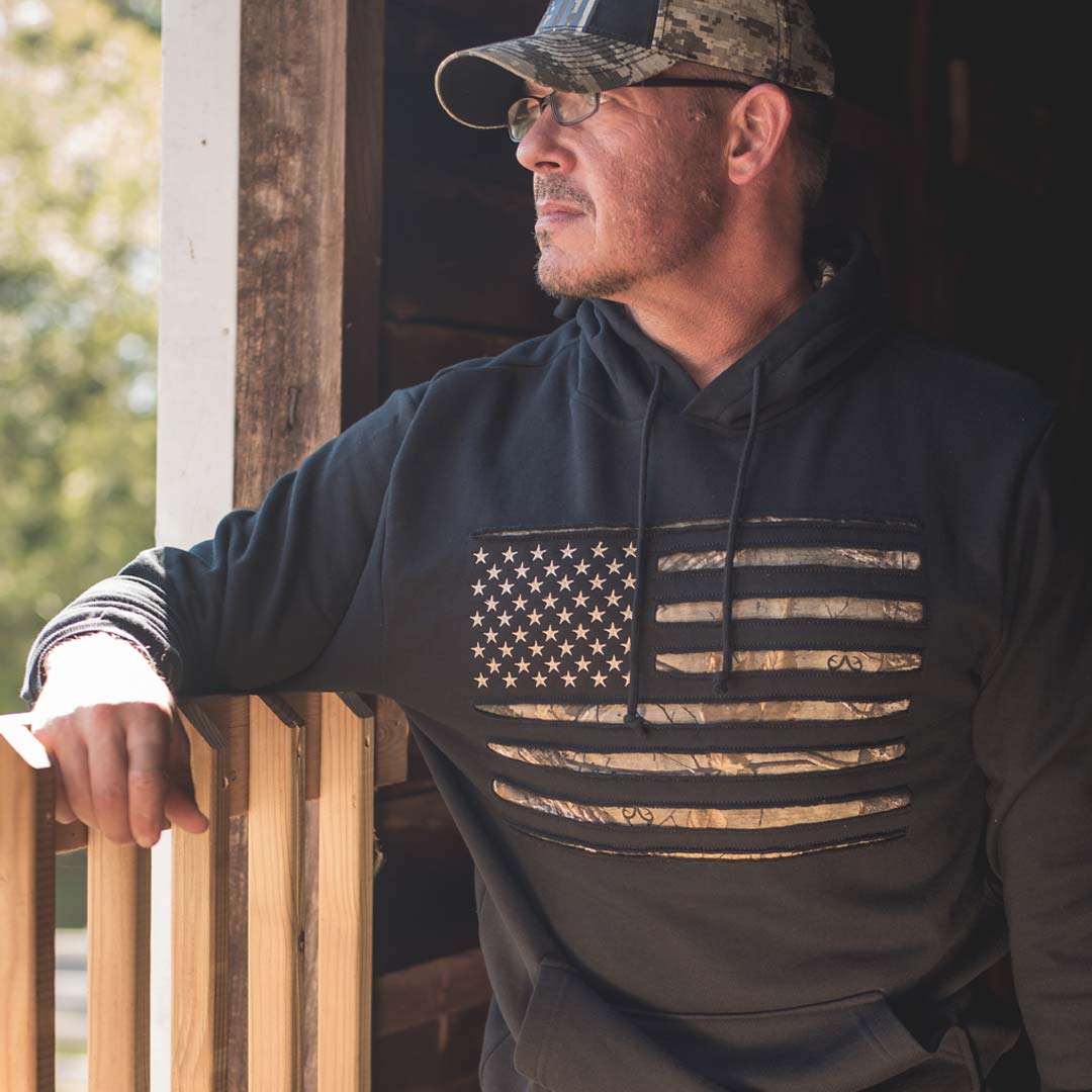 man looking into the distance wearing Camo Stars & Stripes hoodie