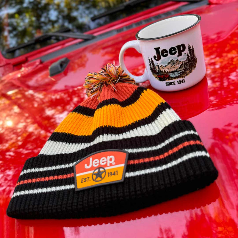 jeep winter beanie with pom pom on top in black, orange, yellow, and white knit colors with jeep shield emblem